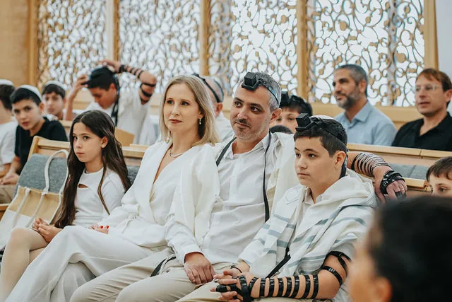 בן עם משפחתו בבית הכנסת ביום העלייה לתורה